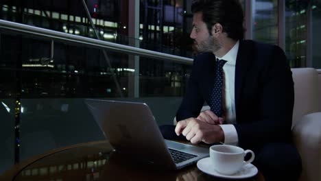 Arabic-businessman-hotel-atrium-night-using-laptop-computer