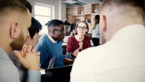 Team-brainstorming-in-trendy-loft-modern-office.-Young-multiethnic-creative-smiling-employees-business-discussion-4K