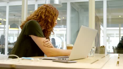 Mujer-de-negocios-trabajando-en-ordenador-portátil-en-el-escritorio-4k