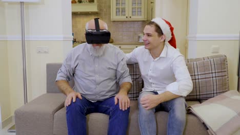 Grandfather-uses-virtual-reality-glasses-with-son
