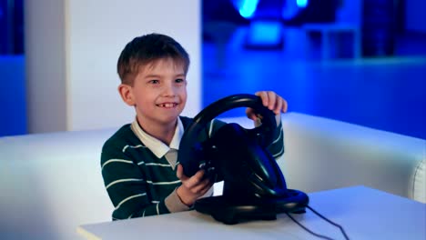 Happy-excited-little-boy-playing-videogame-with-racing-wheel