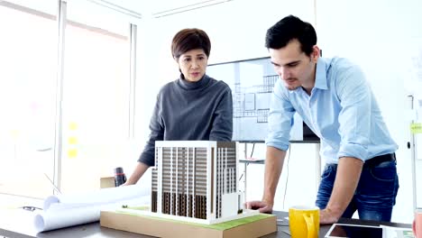 Architect-talking-to-building-project-together.-Attractive-architect-or-engineer-is-concentrating-as-he-examines-the-new-building-project-development.