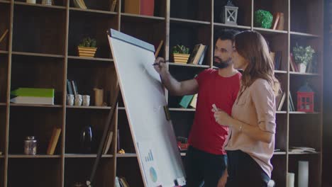 Business-people-writing-business-strategy-on-whiteboard-in-office.-Business-team