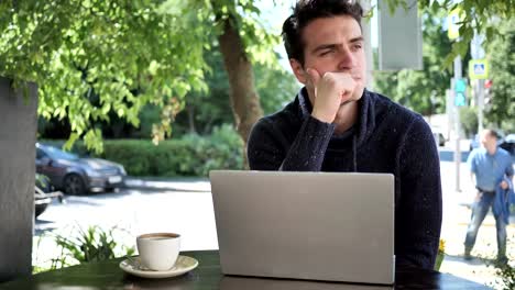 Pensive-Man-Thinking-while-Working-on-Laptop