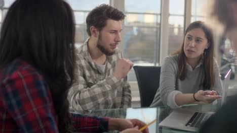 Office-worker-on-laptop-talking-business-to-coworkers-in-new-conference-room