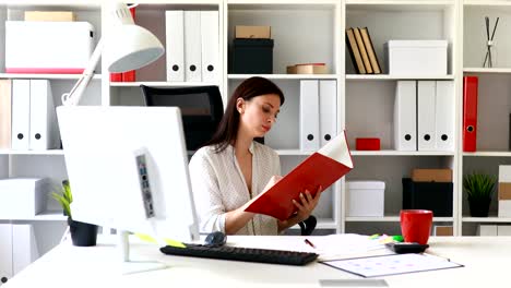 businesswoman-in-white-blouse-examining-documents-in-folder