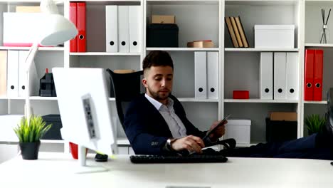 businessman-working-with-legs-on-table-in-office