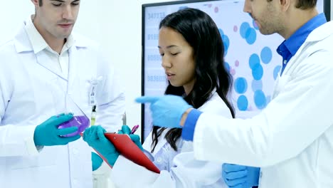 Científicos-o-químicos-hablando-juntos-en-el-laboratorio.-Equipo-de-científicos-trabajando-juntos-en-un-laboratorio.-Resolución-de-4K.