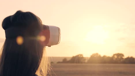 Schöne-Mädchen-in-einem-goldenen-Weizenfeld-nutzt-virtual-Reality-Brille-in-den-Sonnenuntergang-in-Zeitlupe