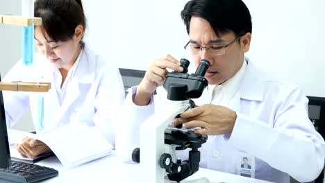 Microscopio-de-uso-científico-asiático-para-trabajo-en-laboratorio.-Personas-con-médicos,-médico,-ciencia,-concepto-profesional-de-la-salud.-Resolución-de-4K.