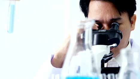 Científico-utilizando-microscopio-para-el-trabajo.-Hombre-científico-trabajando-en-el-laboratorio.-Personas-con-médicos,-médico,-ciencia,-concepto-profesional-de-la-salud.-Resolución-de-4K.