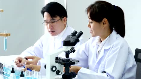 Male-scientist-advise-to-team-how-to-work.-Asian-Scientist-working-together-at-laboratory.-People-with-medical,-science,-doctor,-healthcare-concept.-4K-Resolution.