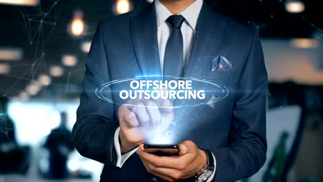 Businessman-With-Mobile-Phone-Opens-Hologram-HUD-Interface-and-Touches-Word---OFFSHORE-OUTSOURCING