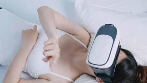 Mujer-ver-dispositivo-de-realidad-virtual-en-cama