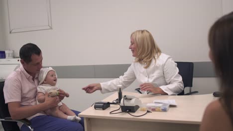 Familia-joven-con-un-niño-pequeño-en-el-médico