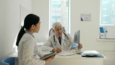 Female-Asian-Doctor-Discussing-X-Ray-with-Senior-Colleague