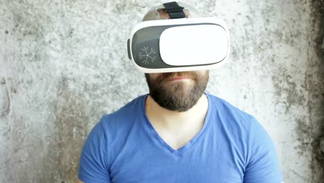 Bearded-man-uses-VR-headset-display-with-headphones-for-virtual-reality-game.
