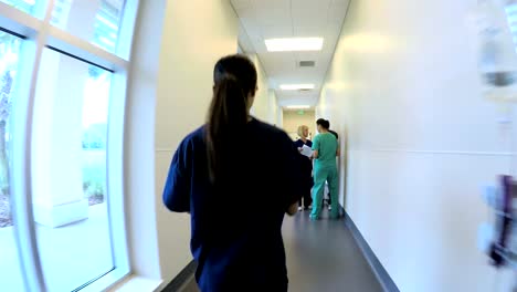 Personal-femenino-étnico-caminando-pasillo-en-centro-médico