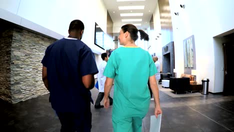 Multi-ethnic-nurses-consulting-in-medical-centre-atrium