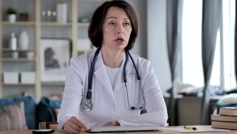 Old-Lady-Doctor-Discussing-with-Patient-in-Clinic