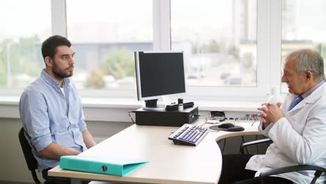 senior-doctor-talking-to-male-patient-at-hospital