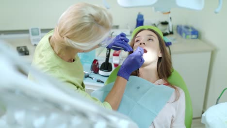 Stomatology-doctor-working-in-dental-clinic.-Female-patient-on-review-of-dentist