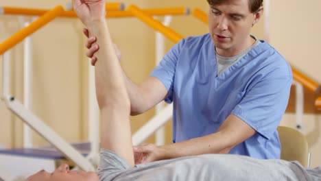 Physiotherapeut-untersucht-Arm-Flexibilität-des-älteren-Menschen