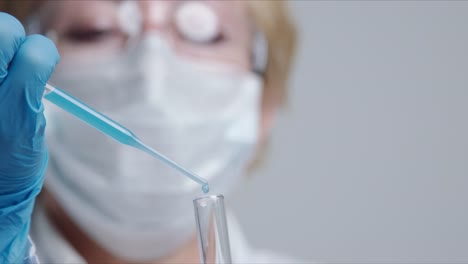 Technician-carefully-drips-the-solution-from-the-pipette-into-glass-tubes.