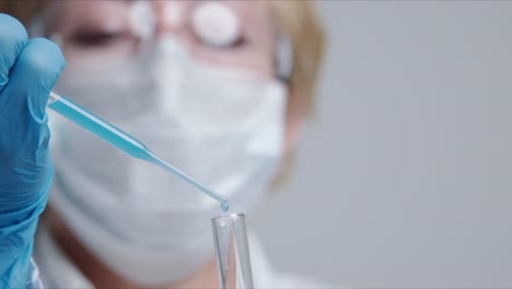 Techniker-tropft-die-Lösung-sorgfältig-aus-der-Pipette-in-Glasröhren.