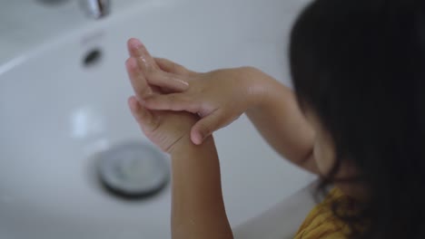 Little-girl-washing-her-hands-to-prevent-virus-and-germs-indoor.