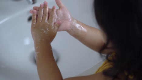 Little-girl-washing-her-hands-to-prevent-virus-and-germs-indoor.