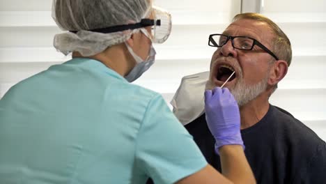 El-técnico-de-laboratorio-toma-un-frotis-de-pacientes-de-edad-avanzada-para-detectar-coronavirus