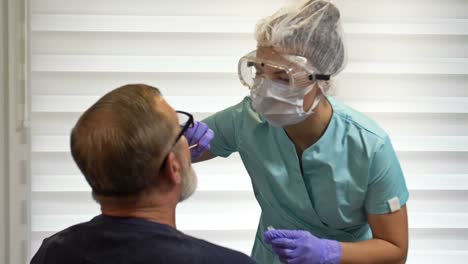 Trabajador-del-hospital-toma-frotis-del-paciente-para-hacer-pruebas-de-coronavirus