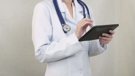 The-doctor-in-a-white-coat-working-with-the-tablet