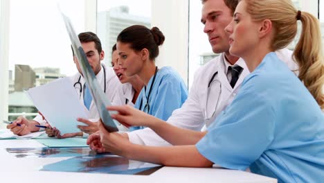 Medical-team-looking-at-xray-and-files-during-meeting