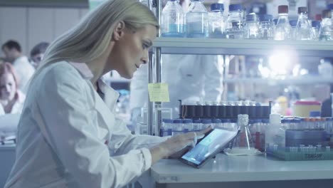 Female-scientist-is-using-a-tablet-while-working-in-a-laboratory.