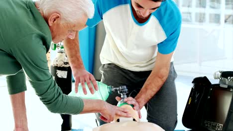 Two-male-paramedics-giving-oxygen-to-a-dummy