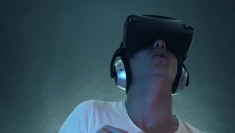 Lachender-junge-Mann-VR-Kopfhörer-tragen-und-virtuelle-Realität-erfahren