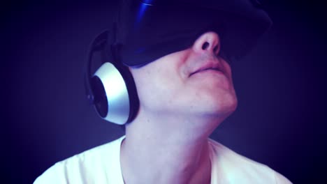 Lachender-junge-Mann-VR-Kopfhörer-tragen-und-virtuelle-Realität-erfahren