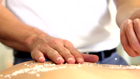 Woman-receiving-salt-scrub-therapy-from-physiotherapist