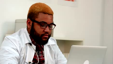 African-american-male-medical-worker-opening-laptop-and-starting-typing