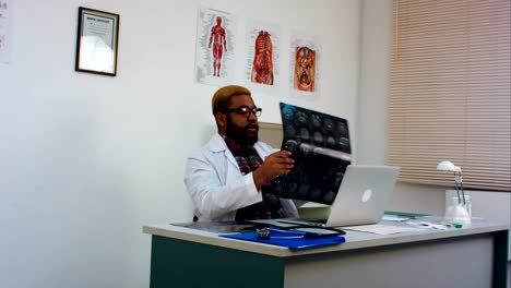 Männlichen-Arzt-diskutieren-Gehirn-Röntgenaufnahme-mit-Patienten-auf-Skype