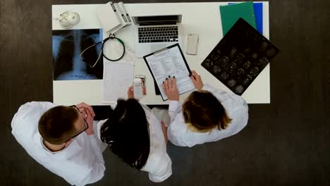 Medizinisches-Team-diskutieren-was-Pillen-verschreiben,-mit-laptop