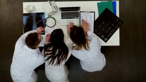 Drei-konzentrierte-Ärzte-mit-Laptop-im-Büro