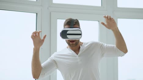 Junger-Mann-haben-VR-Erlebnis-mit-virtual-Reality-Kopfhörer-mit-Händen-Gesten-zur-Steuerung