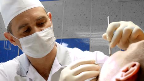 Dentist-very-carefully-check-up-and-repair-tooth-of-his-young-female-patient