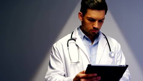 Doctor-using-digital-tablet-in-corridor