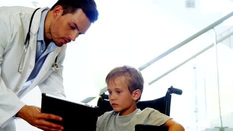 Doctor-showing-digital-tablet-to-disable-boy