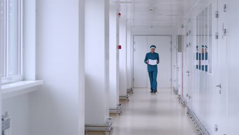 Man-in-uniform-carry-white-paper-in-corridor.-Male-worker-with-pile-of-paper