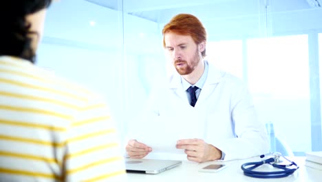 Doctor-Reading-Medical-Reports-of-Patient,-Sitting-in-Front